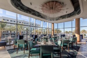 Del Frisco's Double Eagle Steakhouse San Diego dining room featuring an elaborate glass chandelier and floor to ceiling windows