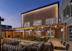 A nighttime view of the paio at Topgolf Boise. The space features seating, fire pits and beautiful outdoor lighting