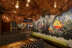 A woven light fixture accents a full wall mosaic at Nando's West Loop in Chicago, IL