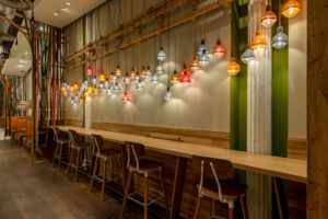 Lanterns line the wall above bar seating at Nando's Wabash location in Chicago, IL