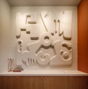 Plaster artwork depicts abstract forms reminiscent of Mayan art